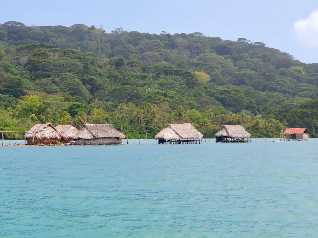 Tradycyjne chaty nad wodą w San Blas, Panama, otoczone dżunglą.