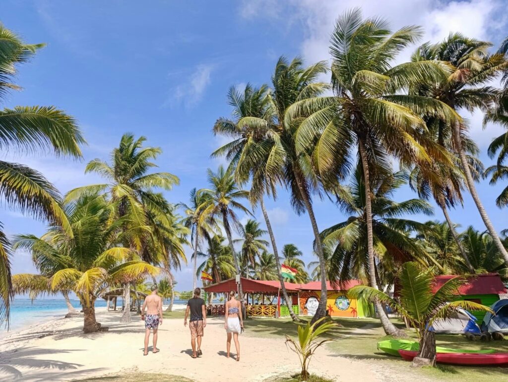 Malownicza tropikalna plaża w Panamie z palmami i ludźmi spacerującymi wzdłuż brzegu.