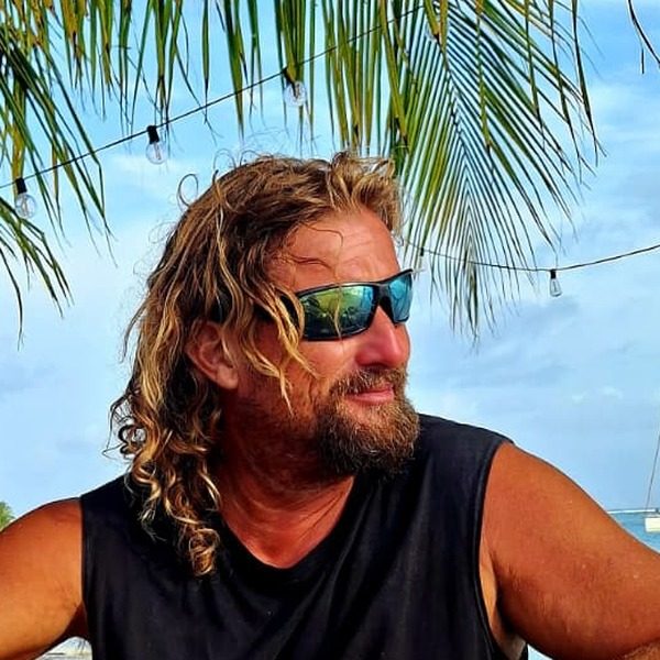 Łukasz, kapitan jachtu Two Moons, na plaży archipelagu San Blas pod palmami